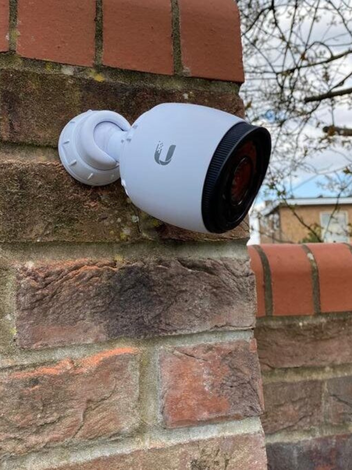 UniFi Security Camera mounted on a brick wall