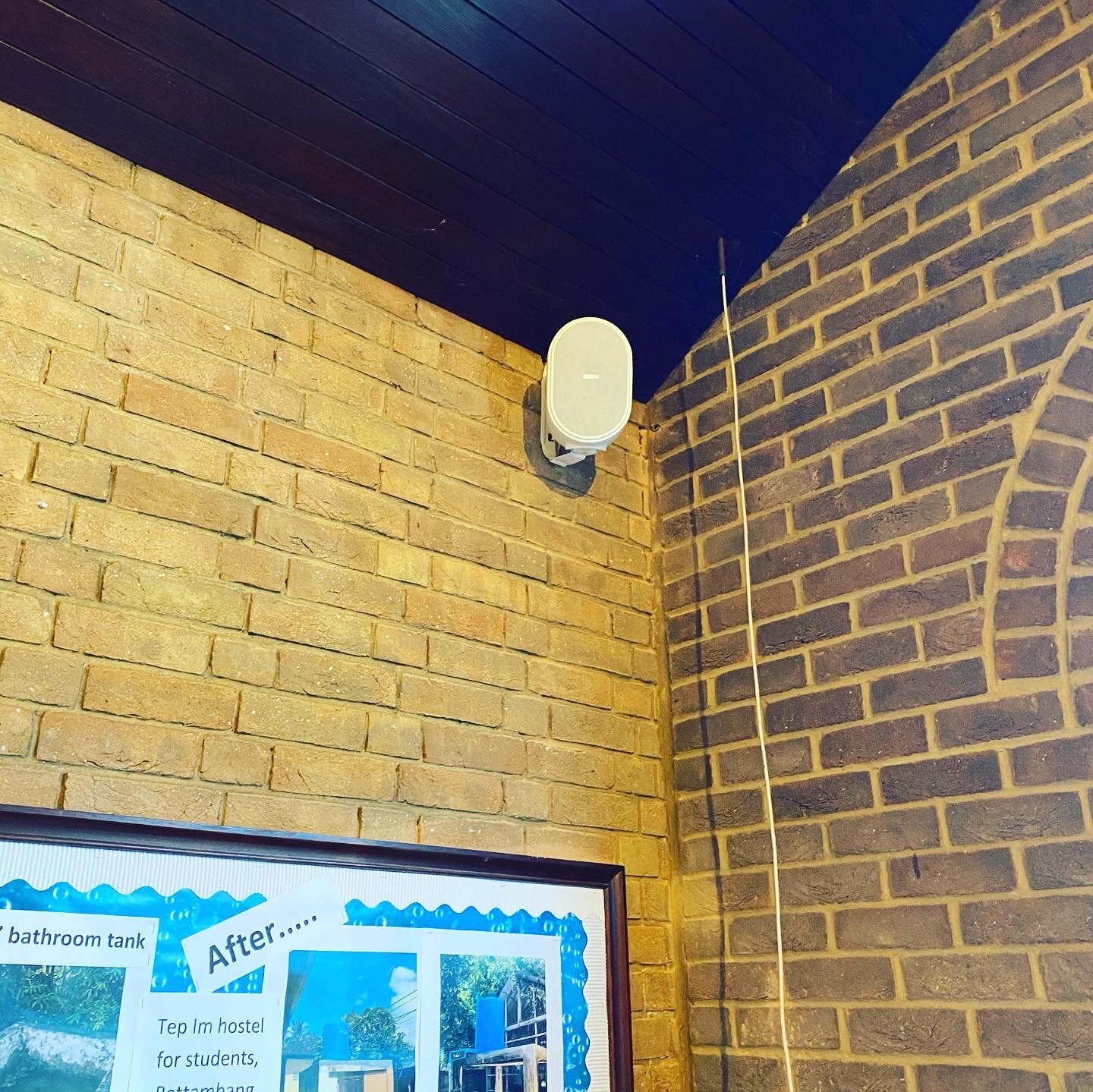 Close up of a speaker attached to the brick wall inside the church