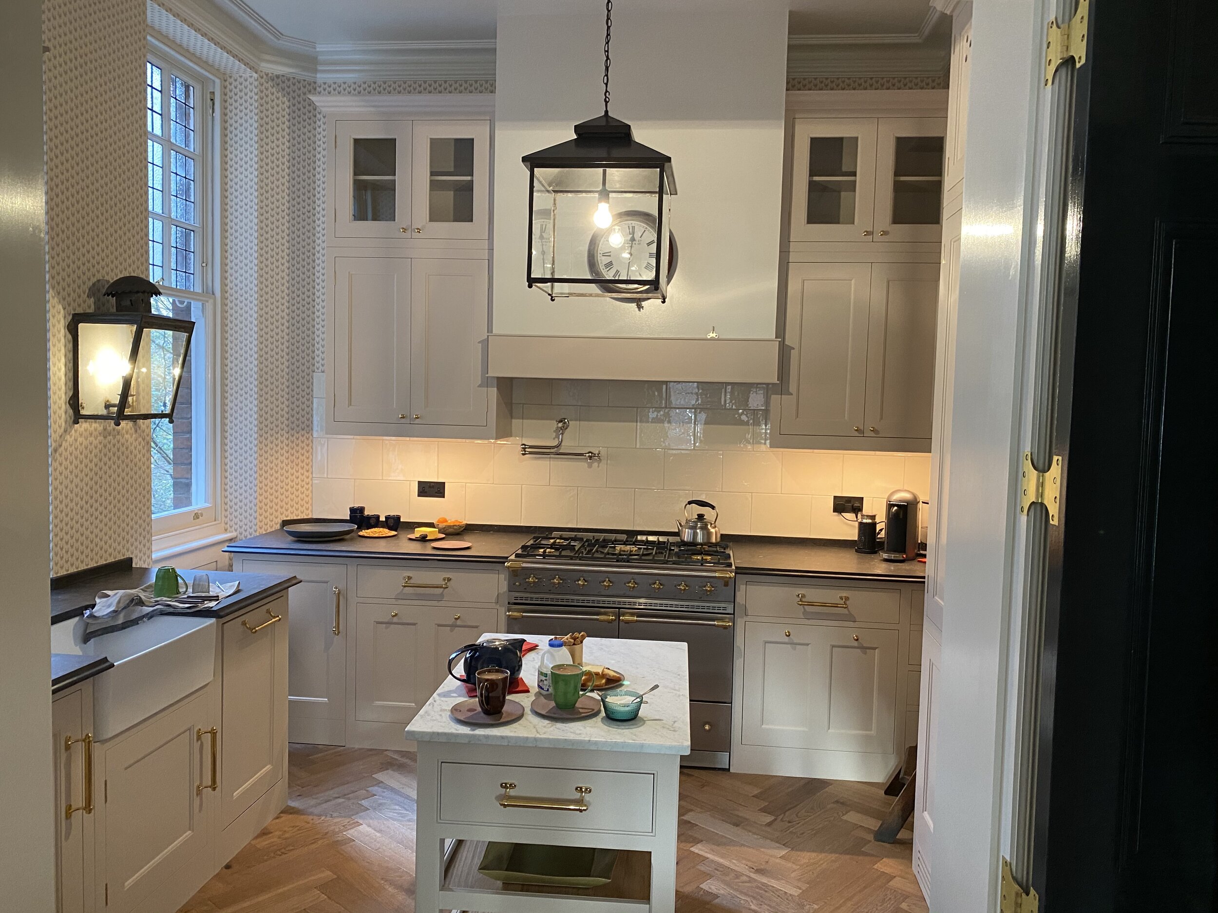 Kitchen with central island, hardwood floors and low hanging large pendant in the middle
