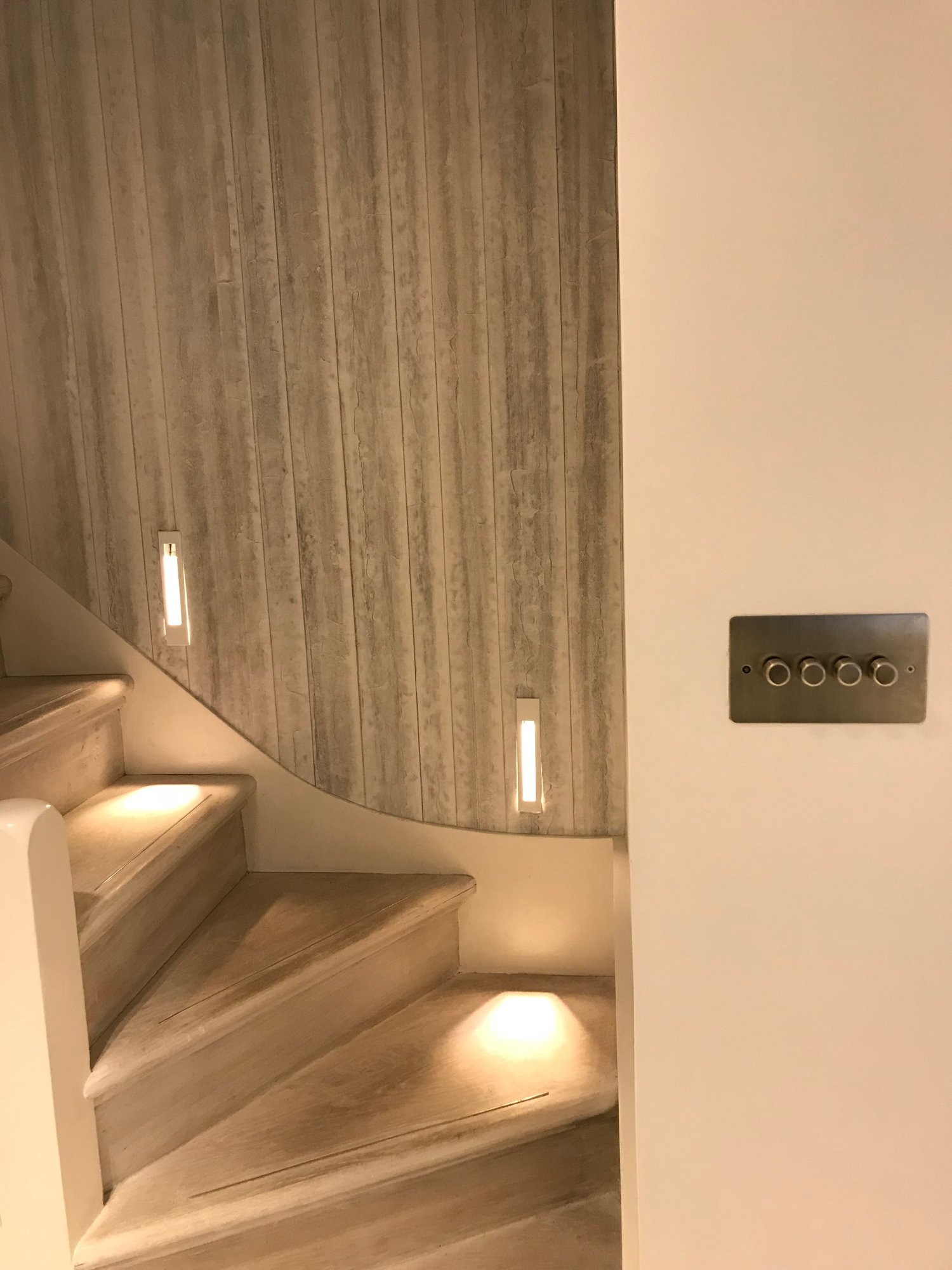 Staircase with LED lights on each step and modern lightswitch next to staircase