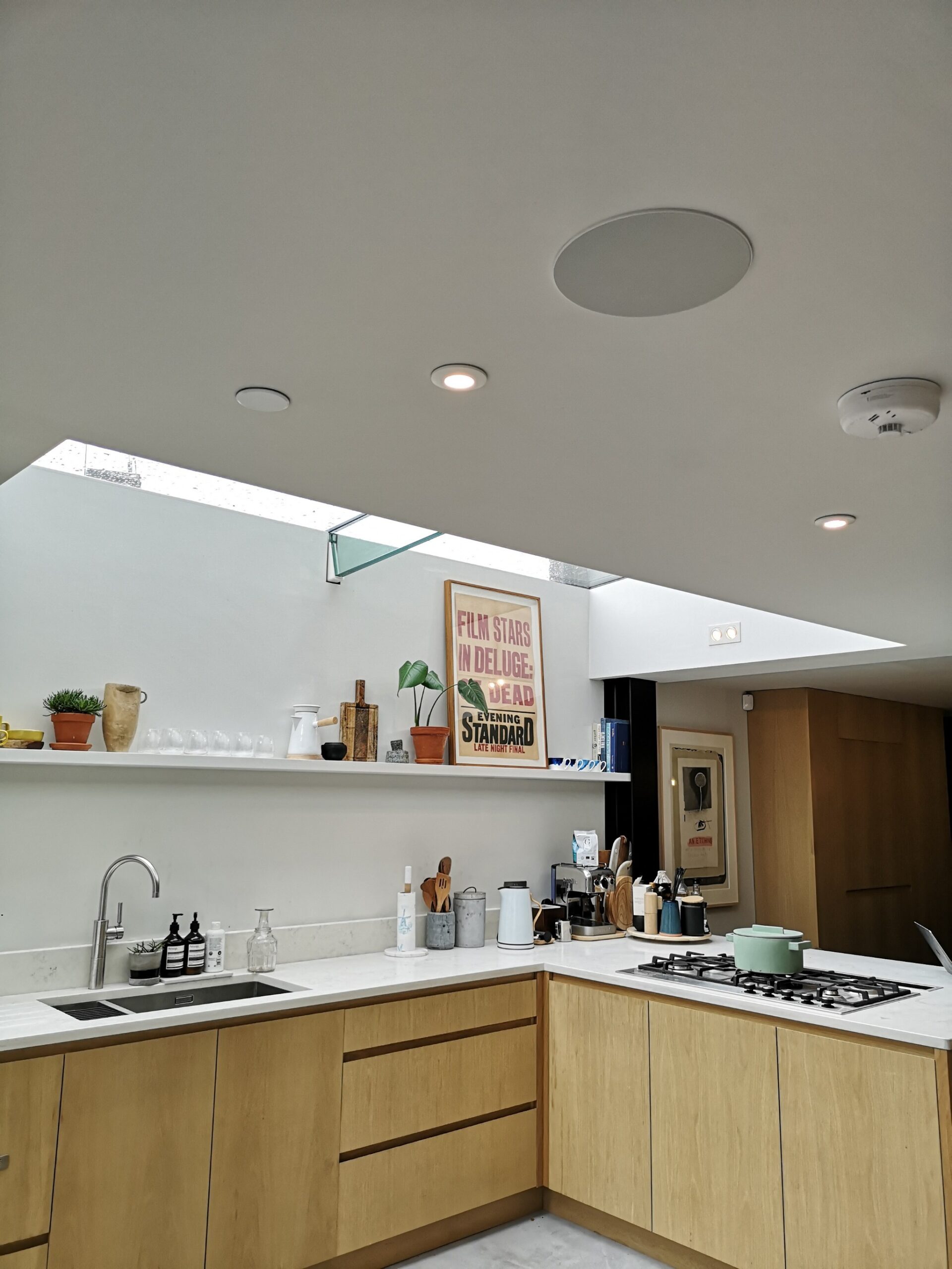 Kitchen showing in-ceiling Klipsch speaker and downlights