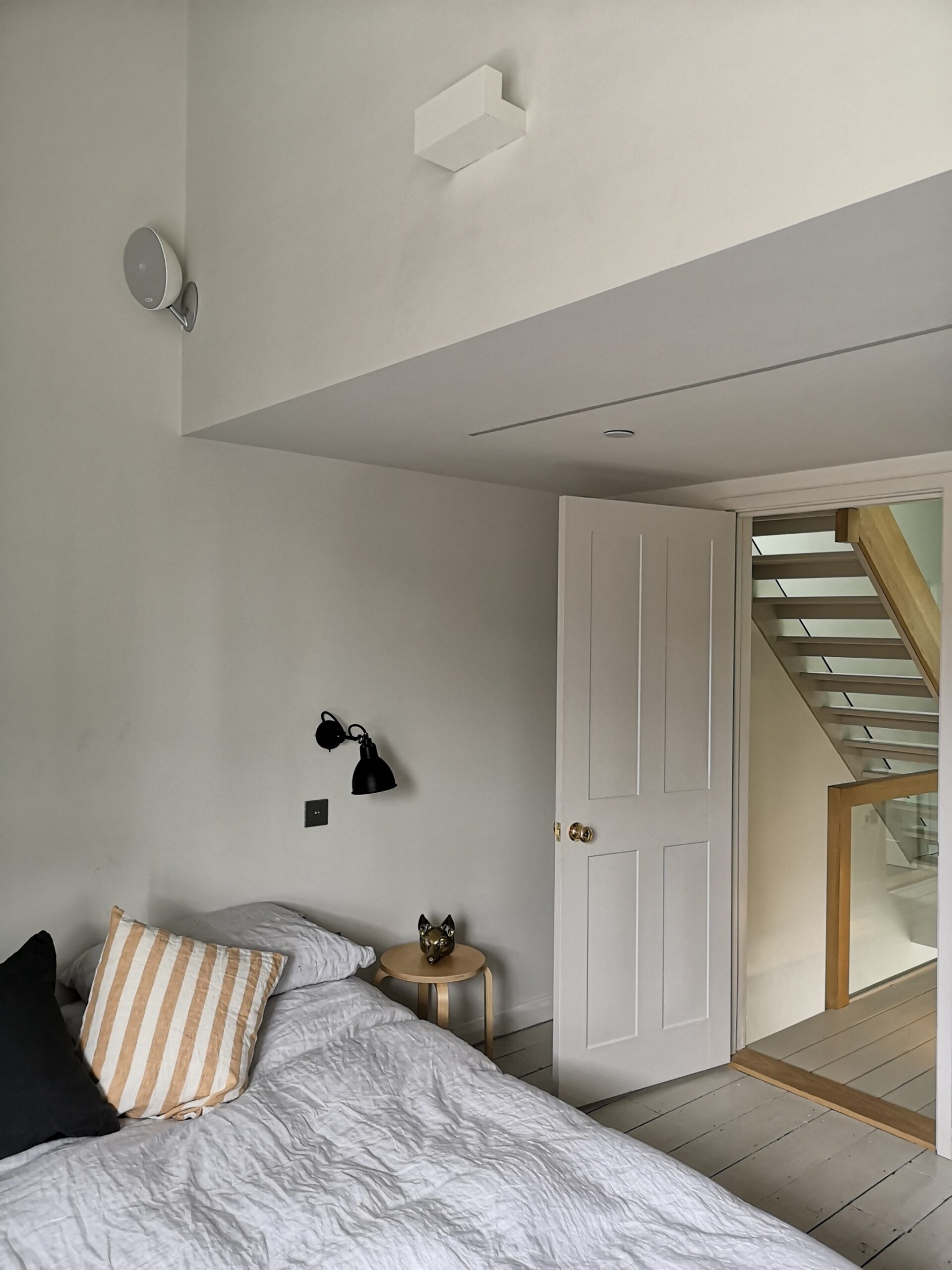 Bedroom with wall mounted speaker above the bed