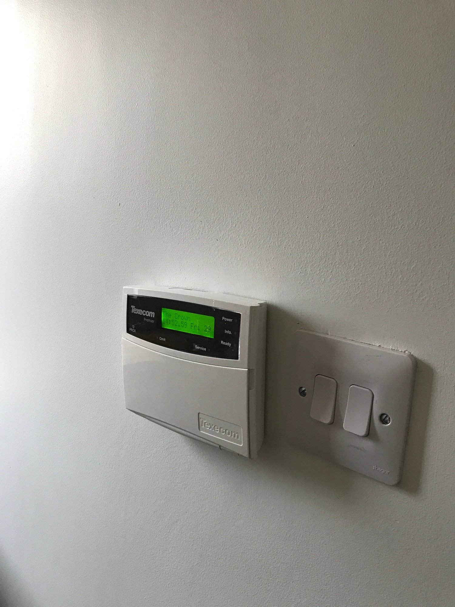 Close up of Texecom alarm system next to light switch
