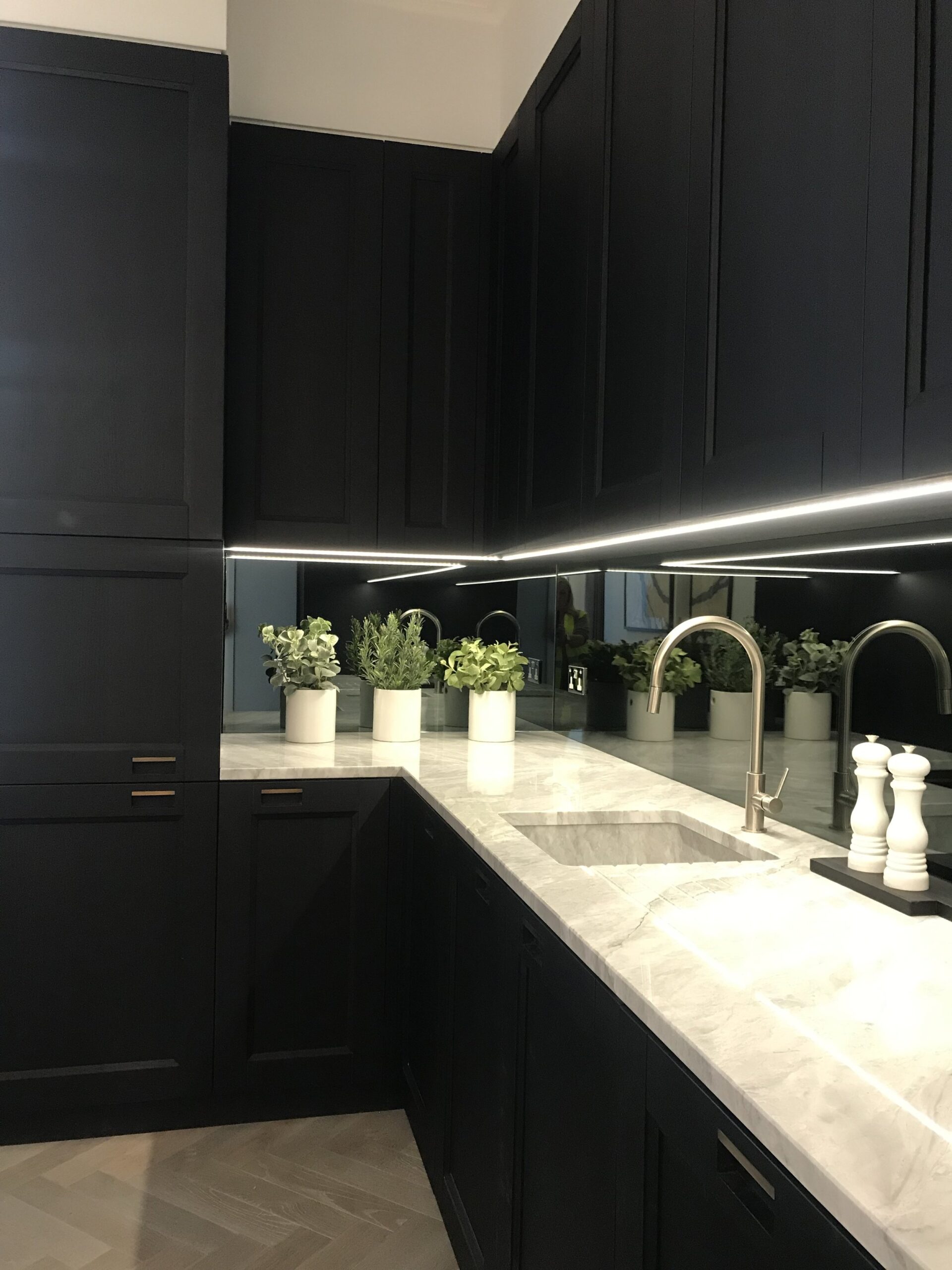 Kitchen with black units and LED lights underneath the cupboards