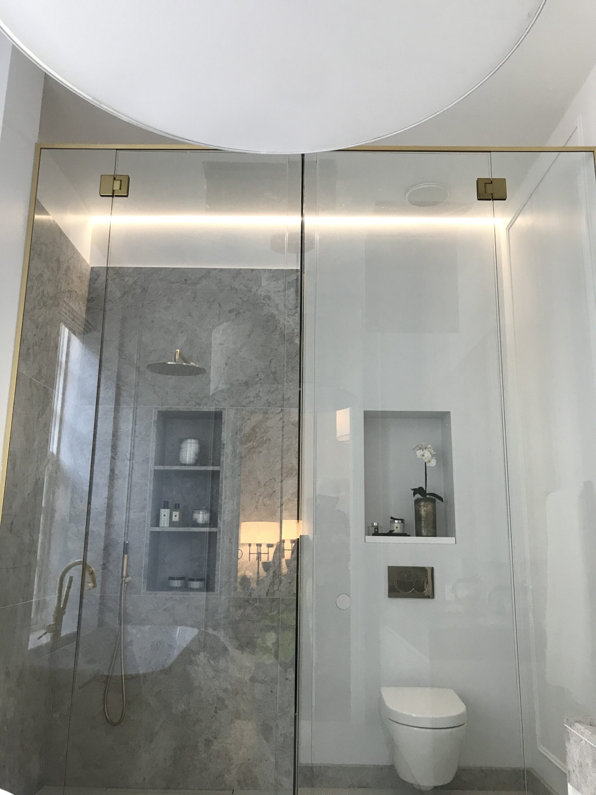 Modern bathroom with glass screen across the toilet and shower