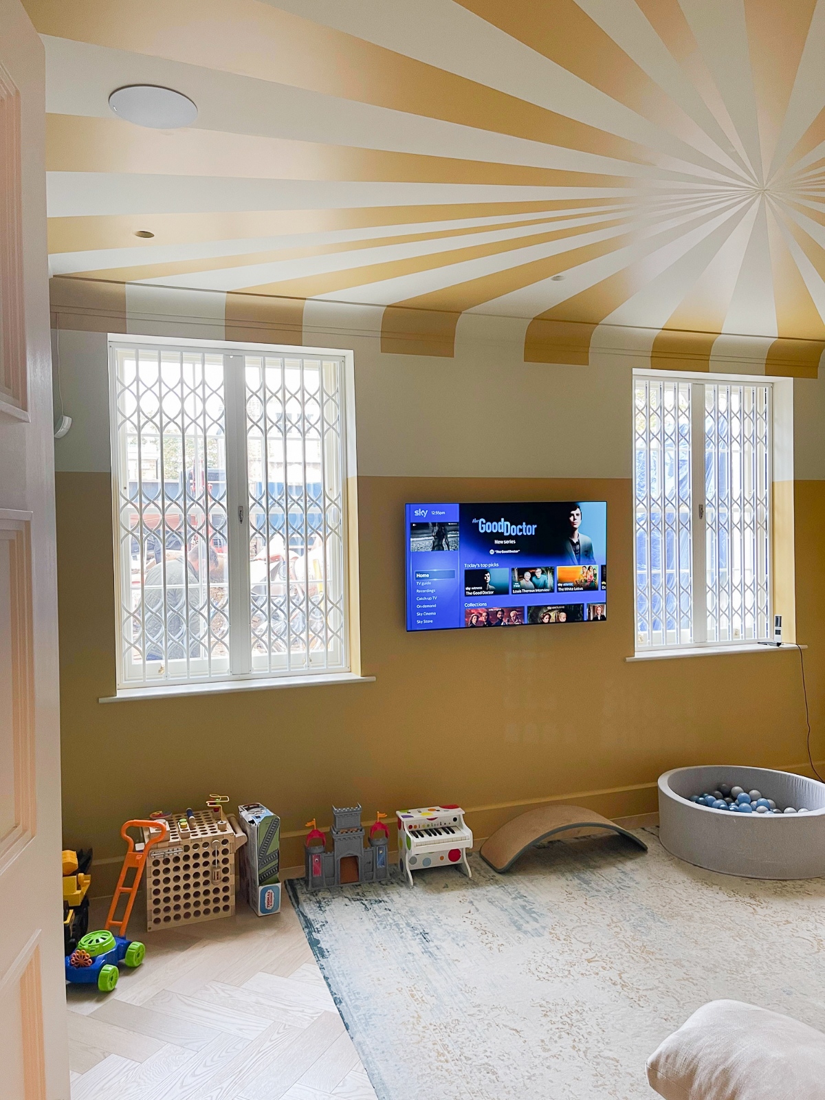 Playroom with circus print ceiling, OLED 4K TV and in-ceiling speakers