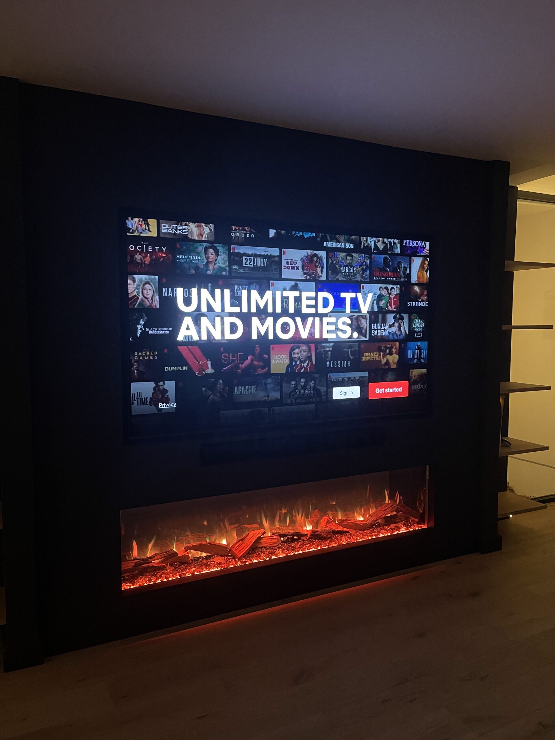Suffolk home interior in the media room with flush mounted Smart TV and soundbar above an electric fireplace
